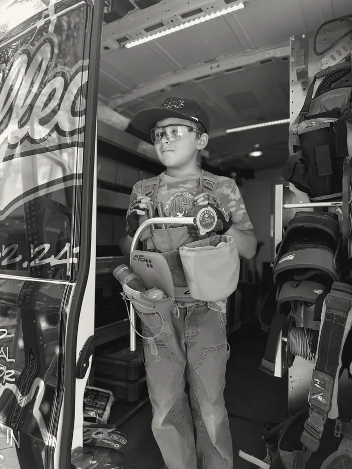A young participant in a tool vest inside the illectric work van