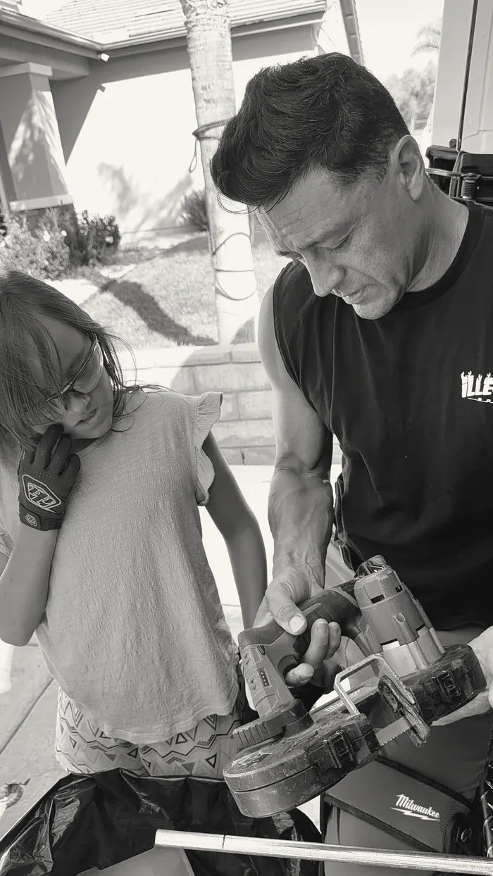 Joe showing a young participant how a band saw works